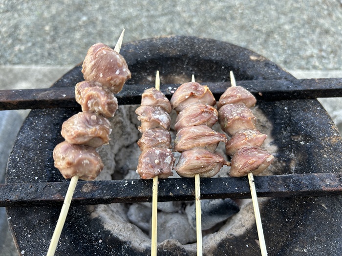 七輪で焼き鳥の砂肝串を炭火で焼き上げているところ