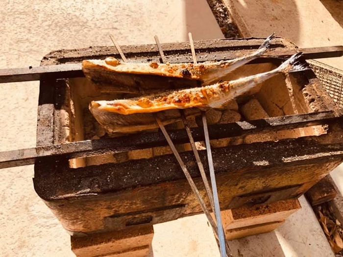 珪藻土の七輪でサンマの炭火焼きを楽しんでいる光景