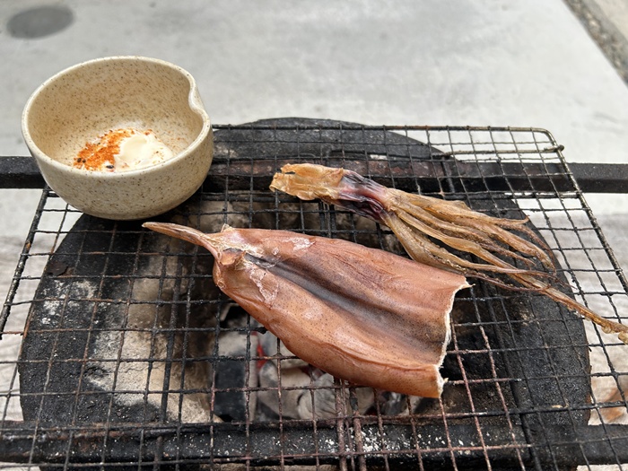 丸型七輪で自家製のスルメを炭火で軽く炙っている