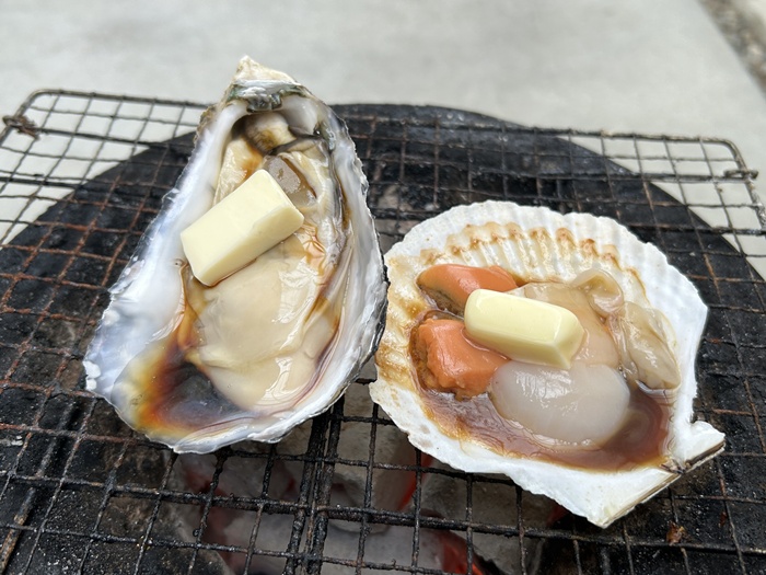 ホタテと牡蠣に醤油バターを入れて七輪で焼く光景