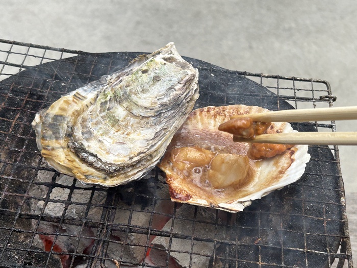醤油バター味で焼けたホタテを食べる光景