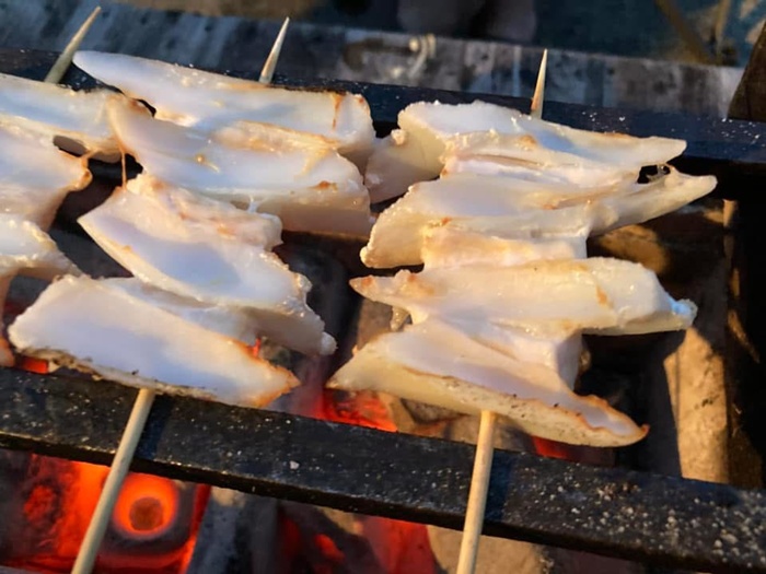 七輪と鉄久をつかって焼き鳥のヤゲン軟骨串を炭火焼きする様子