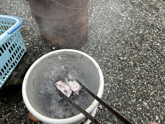 使用した炭の火を水に入れて消火する様子