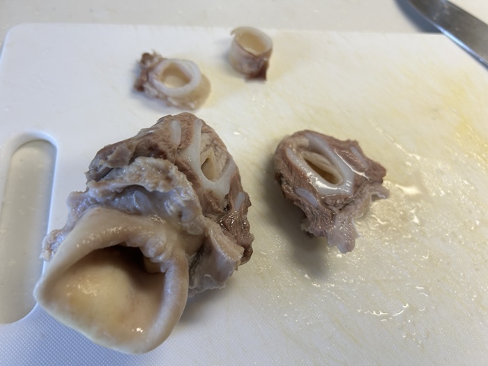 下処理をした豚の喉なんこつを串に刺すために適度なサイズにカットしている様子